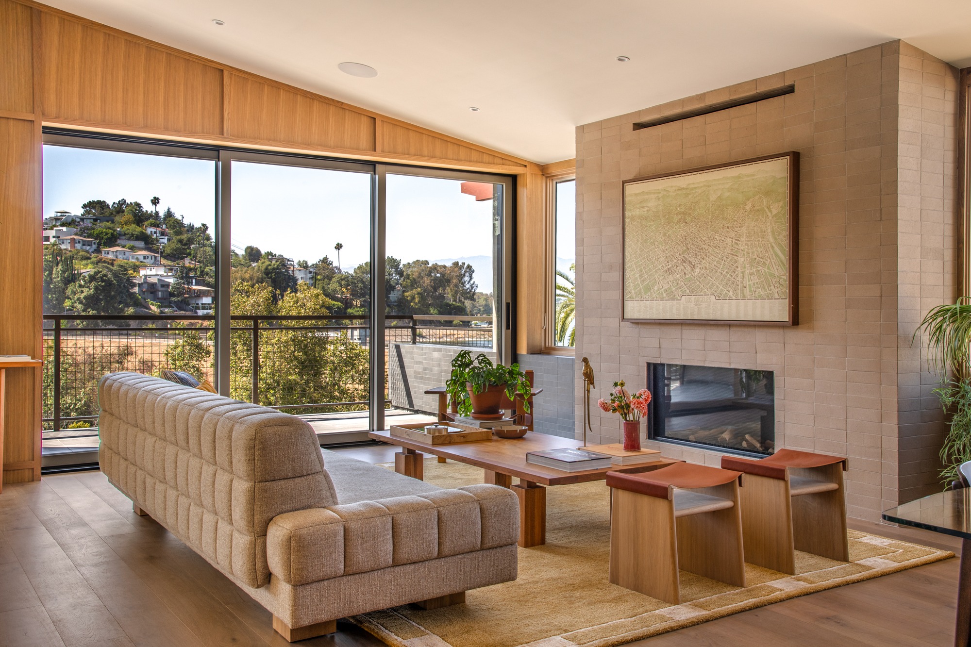 Fanning living room with a fireplace, broad windows and hillside views, actual listing photography